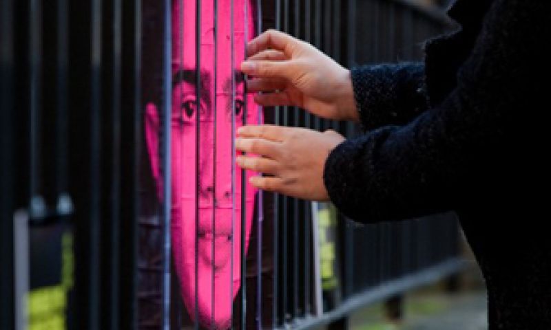 Op of achter de tralies?