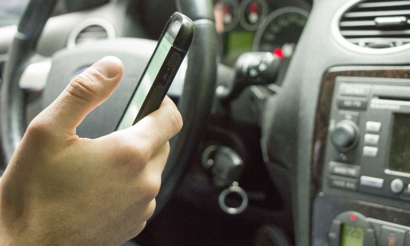 telefoon tijdens rijden achter stuur mobiel vasthouden auto boete